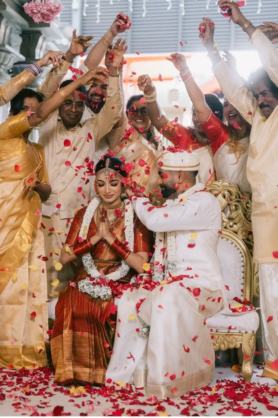 The bride and groom under a shower of petals